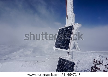 Frozen solar panel on the ridge of Avachinsky volcano in winter