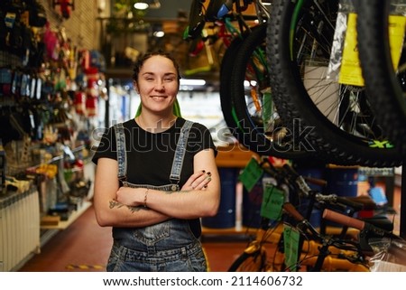 Positive saleswoman smiling in bicycle store