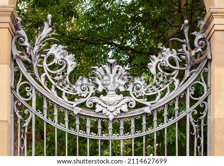 Würzburg, Bavaria  Germany - June 10 2019: The silver ornamental gate with foliage decor and angels head, made out of metal, entrance to the Court Garden of Bavarian Residence in Würzburg Royalty-Free Stock Photo #2114627699