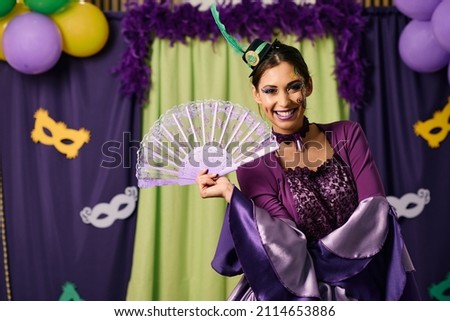 Beautiful woman celebrating Mardi Gras festival and wearing carnival costume on a party while looking at camera.