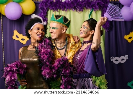 Cheerful friends celebrating Mardi Gras and having fun together on carnival party. 