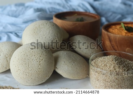 Steamed Little millet cakes or little millet idli. Made with a fermented batter of little millet, lentils. Served with coconut chutney. Shot with little millet in a wooden bowl Royalty-Free Stock Photo #2114664878