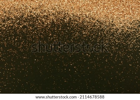 Gold and bronze glitter color confetti dots splash on black. Abstract glow shiny background. 