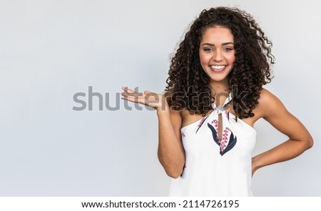 A young Latin girl points to the sides. Advertisement and presentation concept.