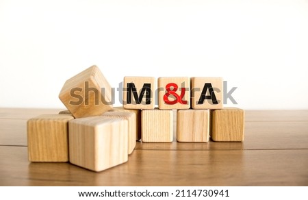 Mergers and acquisitions symbol. Concept words M and A - Mergers and acquisitions on wooden cubes on a beautiful white background. Business, mergers and acquisitions concept. Copy space.