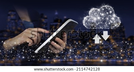 Cloud computing technology internet concept background. Hand touch white tablet with digital hologram cloud, download, data sign on city dark blurred back. Software Update Installation Upgrade Data.