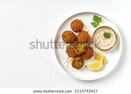 Plate of chickpeas falafel with tahini sauce isolated on white background. Top view, copy space Royalty-Free Stock Photo #2114743427