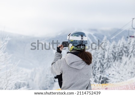 the girl shoots a mountain landscape on the phone.