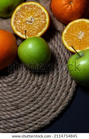 Oranges and apples on a dark background. freshly cut fruit. fruit theme