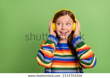 Portrait of attractive cheerful girly girl listening stereo pop hit single copy space isolated over bright green color background