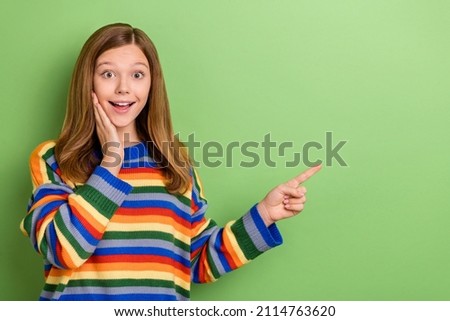 Portrait of attractive girly amazed cheerful girl demonstrating copy space new solution ad isolated over bright green color background