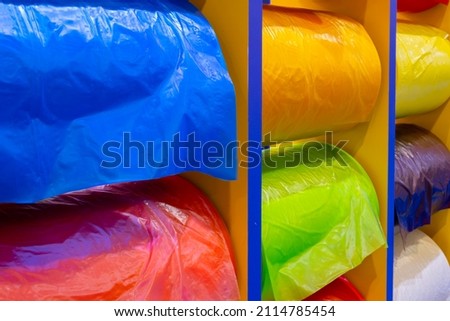 Multicolor rolls of polyethylene film in stock. Modern warehouse and storage systems.