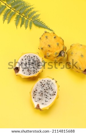 Fresh yellow pitaya on yellow background 