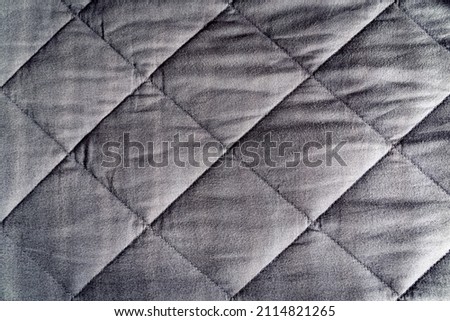 Grey weighted blanket texture detail, heavy padded relaxing bed sheet cover filled with glass beads Royalty-Free Stock Photo #2114821265