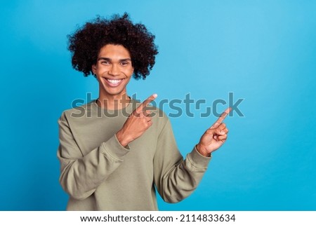 Photo of young cheerful guy indicate fingers empty space direct follow suggest banner isolated over blue color background
