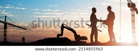 Silhouette Of Two Male Architect Shaking Hands At Construction Site During Sunset