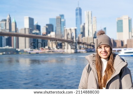 NEW YORK CITY WOMAN ENJOYING MANHATTAN VIEW FROM BROOKLYN PARK LIVING HAPPY DURING WINTER TIME IN UNITED STATES. TRAVEL, SUNNY DAY AND AMERICA CONCEPT.