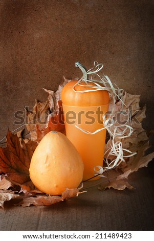 Pile of pumpkins with autumn foliage on abstract background