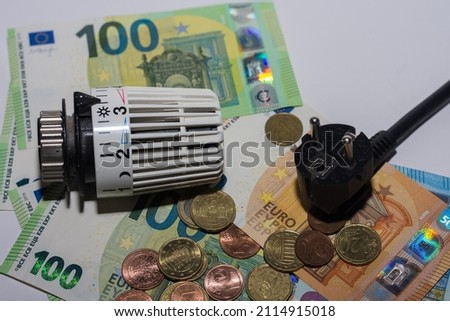 Energy prices increase and energy consumption thermostatic controller heating and electricity plug with money macro view Royalty-Free Stock Photo #2114915018
