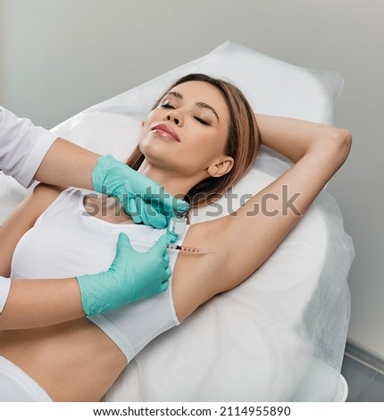 Woman receiving underarm hyperhidrosis treatment. Armpit injections to prevent excessive sweating with beautician at cosmetology Royalty-Free Stock Photo #2114955890