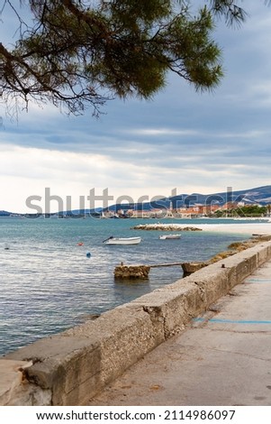 Moored boat. Embankment in Croatia, Kastel Luksic. View of the Adriatic Sea and mountains. In the background is the city of Trogir. Selective focus.