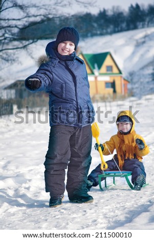 two  happy boys on sled