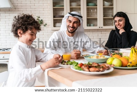 happy family from arab united emirates eating together and celebrating the national day holidays Royalty-Free Stock Photo #2115022322