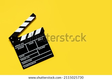 clapperboard for film shooting on a yellow background copy space
