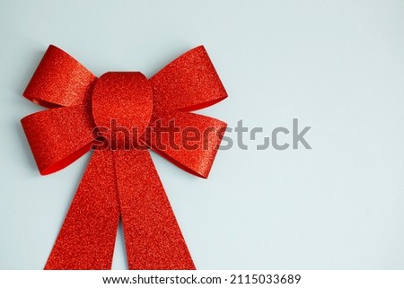 Close up red big present bow on the blue background. Romantic love concept with copy space