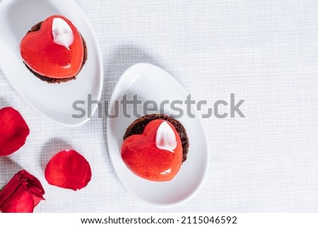 Valentine's day Heart shaped chocolate and strawberry cake on a white plate placed on white background. Celebration of love concept.