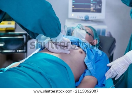 Close-Up on Asian Surgical Team Performing CPR on Heart Attack Patient in Hospital Operating Room Royalty-Free Stock Photo #2115062087