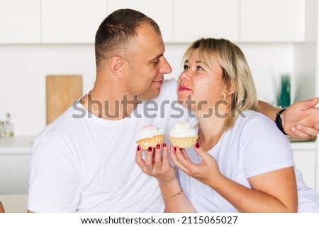 Happy couple having cakes in the kitchen	