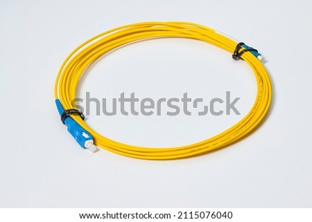 Fiber optic patch cord of yellow color on a white background.