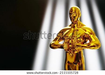 Hollywood Golden Oscar Academy award statue on light rays on black background with copy space. Success and victory concept. Royalty-Free Stock Photo #2115105728