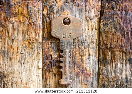 Rusty key on wooden background 