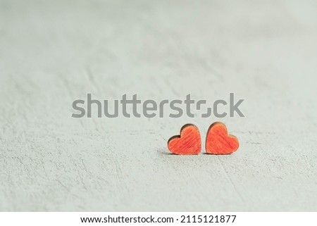 two red hearts on a blurry concrete background out of focus, the concept of Valentine's Day and March 8