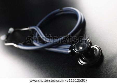 Black stethoscope on a dark matte background