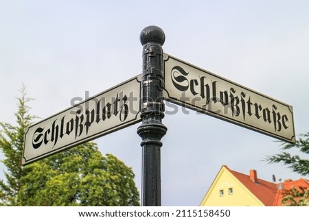 German antique street sign with the street names "Schloßstraße" and "Schloßplatz" which translates into "Castle street" and "Castle place" in English language