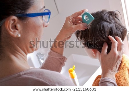 Mother removing lice from her child