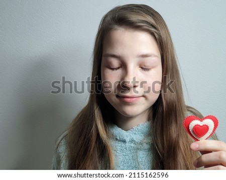 portrait of a teenage girl with a heart in her hand, congratulations on valentine's day.