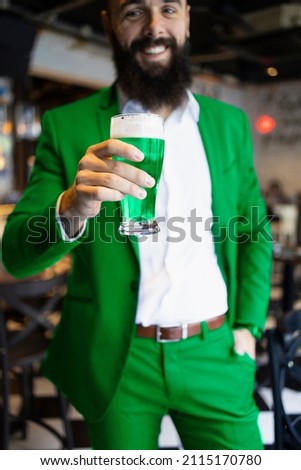 Bearded man dressed in green for St. Patrick's Day holding a beer Royalty-Free Stock Photo #2115170780