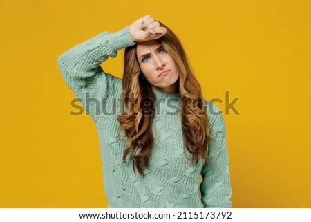 Young sick ill tired caucasian woman 30s wearing green knitted sweater put hand on forehead suffer from headache isolated on plain yellow color background studio portrait. People lifestyle concept.