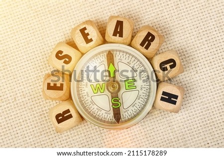 Business concept. On the table is a compass and cubes with the inscription - RESEARCH