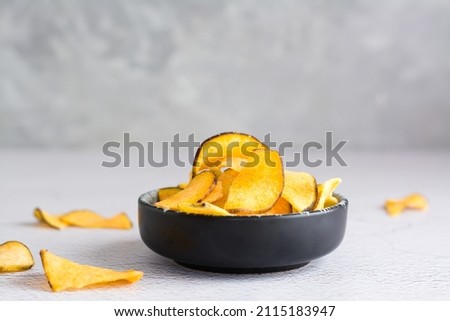 Appetizing sweet potato chips in a bowl on the table. Homemade snack. Copy space Royalty-Free Stock Photo #2115183947