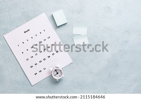 Blank sheet of monthly calendar, pages to write and alarm clock on the desktop. Time planning and organizationю. Copy space