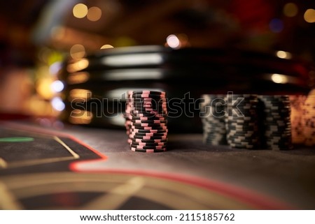 Poker chips colorful gaming pieces lie on the game table in the stack. Background for gambling, casino, business, poker. Colorful casino chips for casino game on the table. Soft focus Royalty-Free Stock Photo #2115185762