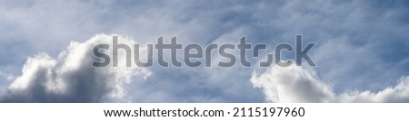 Reflection of blue sky and white and gray clouds on smooth water of Lake Washington, as an abstract nature background
