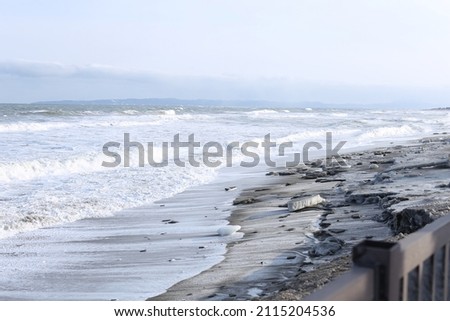Winter landscape with frozen sea and icy beach. Dramatic seascape. Storm and snow weather. 
