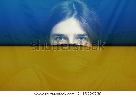 War between Russia and Ukraine. Young woman with sad sight looking at camera. Art portrait. Mental health concept. Face of depression. Caucasian woman with green eyes on black background. Royalty-Free Stock Photo #2115226730