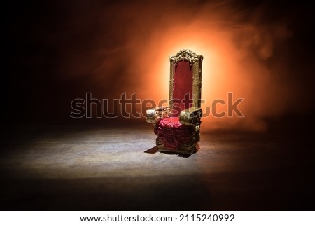 Red royal chair miniature on wooden table. Place for the king. Medieval Throne. Selective focus Royalty-Free Stock Photo #2115240992